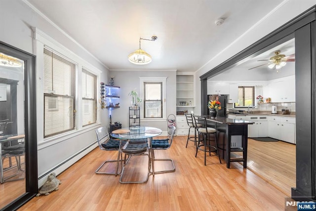 178-180 17th Ave, Paterson, NJ 07504 - dining space with light wood finished floors, a ceiling fan, ornamental molding, and a baseboard radiator