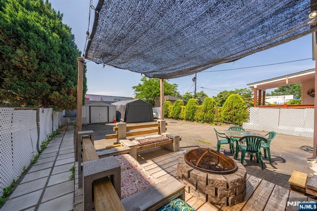 178-180 17th Ave, Paterson, NJ 07504 - wooden deck with a fire pit, a storage unit, a fenced backyard, outdoor dining area, and a patio area