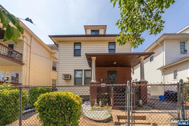 178-180 17th Ave, Paterson, NJ 07504 - rear view of house with a gate, brick siding, a fenced front yard, a wall unit AC, and covered porch