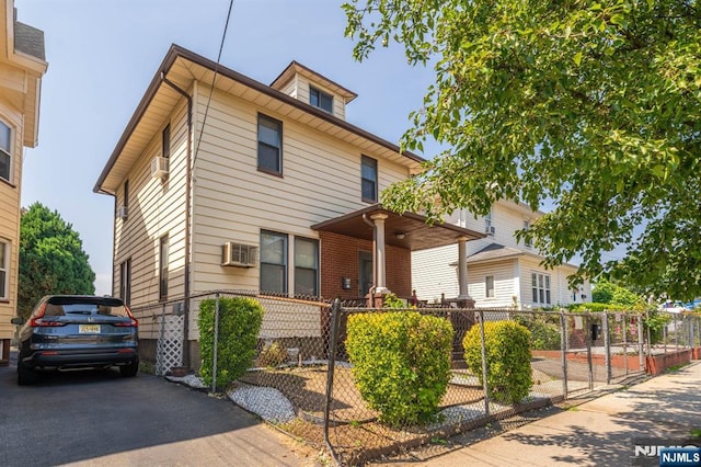 178-180 17th Ave, Paterson, NJ 07504 - american foursquare style home featuring a fenced front yard, a wall mounted AC, and cooling unit