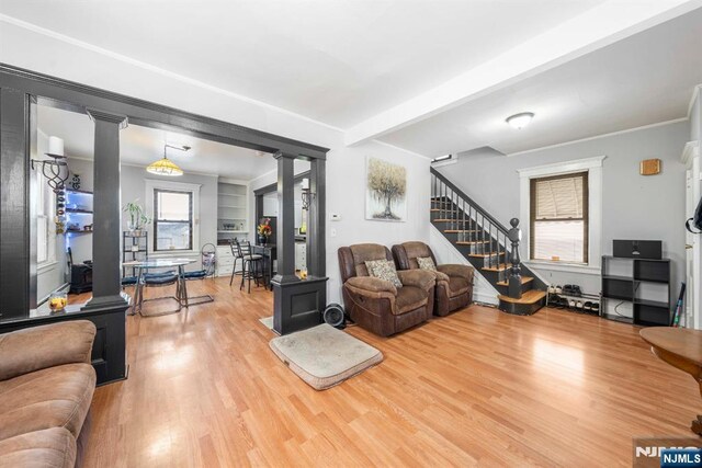 178-180 17th Ave, Paterson, NJ 07504 - living room with decorative columns, wood finished floors, and stairway