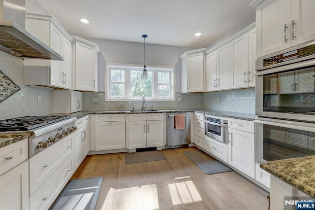 178 Arthur St, Hillsdale, NJ 07642 - kitchen with stainless steel appliances, wall chimney range hood, white cabinets, light wood-type flooring, and recessed lighting