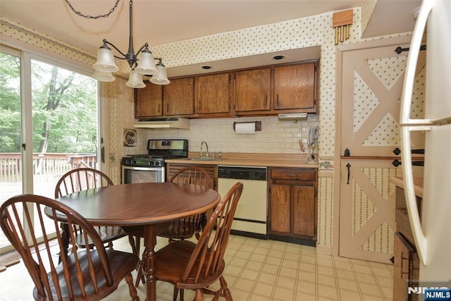 29 Lotus Ln, Waldwick, NJ 07463 - kitchen featuring dishwasher, gas stove, under cabinet range hood, brown cabinetry, and a chandelier