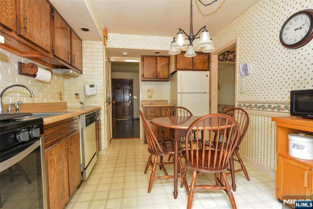 29 Lotus Ln, Waldwick, NJ 07463 - kitchen with wallpapered walls, freestanding refrigerator, stove, dishwasher, and a chandelier