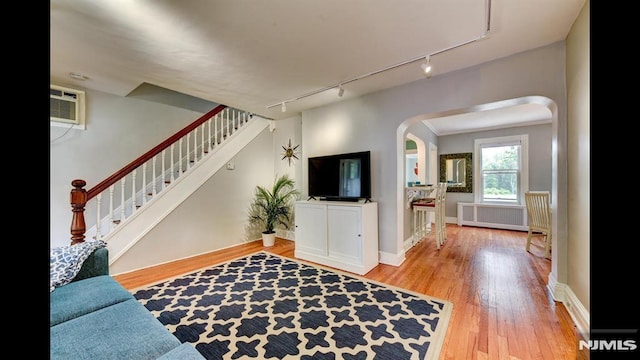 118 High St, Nutley, NJ 07110 - living room with track lighting, arched walkways, radiator, wood finished floors, and an AC wall unit