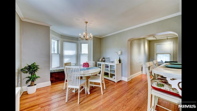 118 High St, Nutley, NJ 07110 - dining area with light wood-type flooring, a chandelier, arched walkways, and crown molding