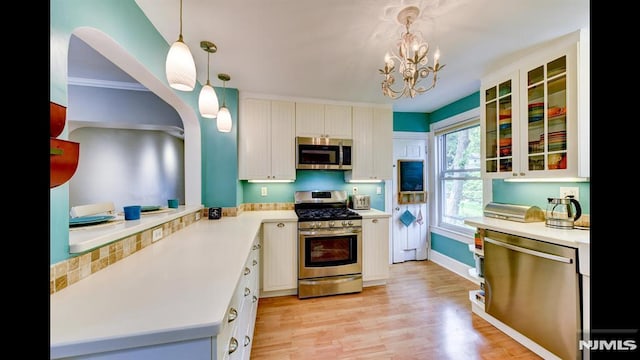 118 High St, Nutley, NJ 07110 - kitchen with stainless steel appliances, light countertops, light wood-style floors, and a chandelier