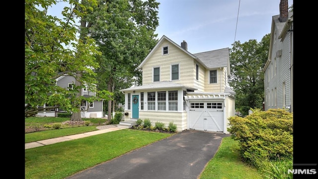 118 High St, Nutley, NJ 07110 - view of front facade with a chimney, a garage, roof with shingles, driveway, and a front lawn