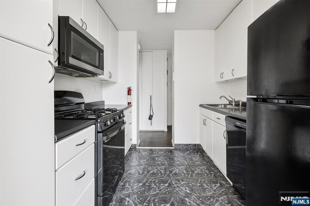 9060 Palisade Ave Unit 511, North Bergen, NJ 07047 - kitchen with black appliances, dark countertops, and white cabinetry