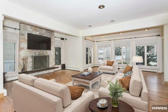 237 Elm Ave, Teaneck, NJ 07666 - living room featuring wood finished floors, a fireplace, a baseboard heating unit, and recessed lighting