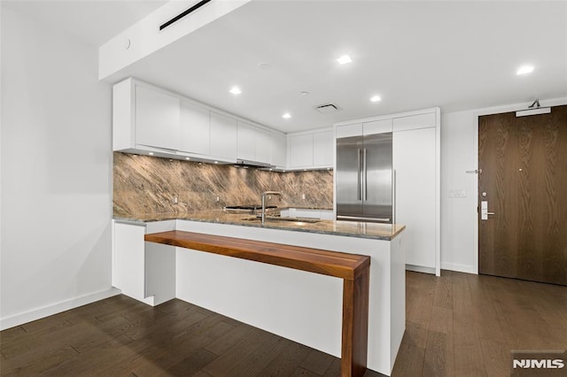 320 Adolphus Ave Unit 604, Cliffside Park, NJ 07010 - kitchen with a peninsula, dark stone counters, dark wood-style flooring, and recessed lighting