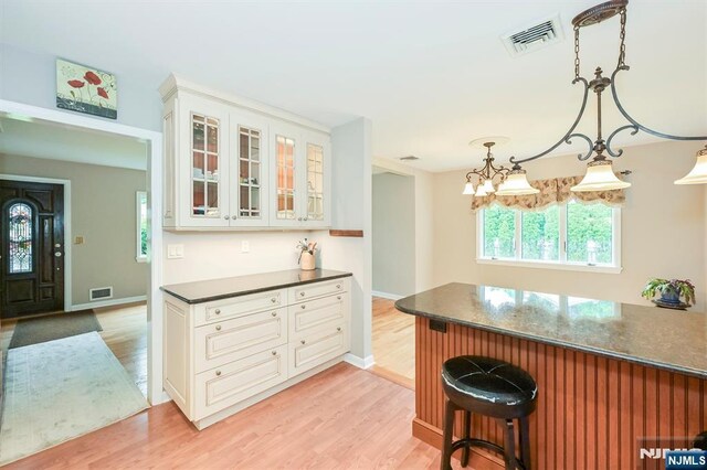 16 Murray Rd, Montvale, NJ 07645 - kitchen with dark countertops, light wood-type flooring, a kitchen bar, and glass insert cabinets