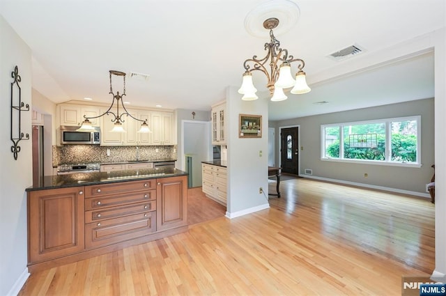 16 Murray Rd, Montvale, NJ 07645 - kitchen with appliances with stainless steel finishes, tasteful backsplash, light wood-style flooring, glass insert cabinets, and pendant lighting