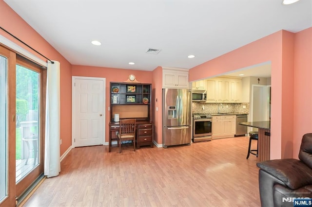 16 Murray Rd, Montvale, NJ 07645 - kitchen featuring appliances with stainless steel finishes, light wood finished floors, tasteful backsplash, cream cabinets, and dark countertops
