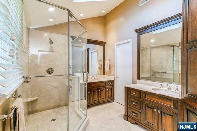 74 O Shaughnessy Ln, Closter, NJ 07624 - full bathroom with a stall shower, two vanities, a skylight, tile patterned floors, and recessed lighting