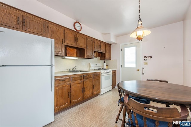 744 9th St, Carlstadt, NJ 07072 - kitchen with white appliances, light countertops, hanging light fixtures, and brown cabinetry
