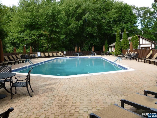1907 Faulkner Ct, Mahwah, NJ 07430 - community pool with a patio and view of wooded area
