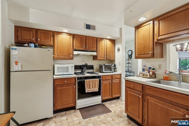 1907 Faulkner Ct, Mahwah, NJ 07430 - kitchen with white appliances, under cabinet range hood, light countertops, brown cabinetry, and recessed lighting