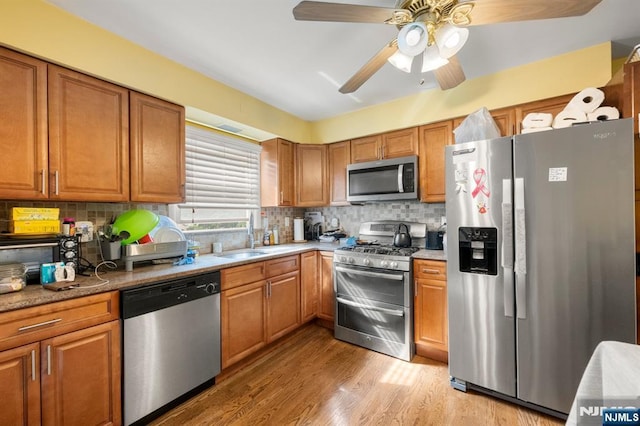 105 Old Hoboken Rd, Hackensack, NJ 07601 - kitchen featuring appliances with stainless steel finishes, brown cabinetry, and backsplash