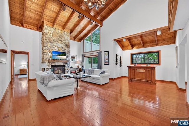 11 Country Ln, Mahwah, NJ 07430 - living area with a wood ceiling with exposed beams, high vaulted ceiling, a stone fireplace, healthy amount of natural light, and wood-type flooring
