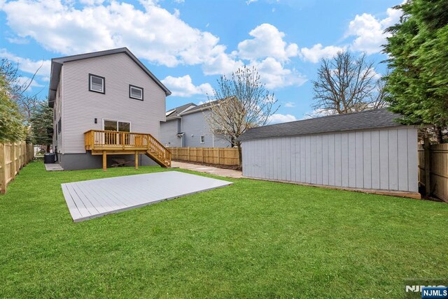 222 4th St, Ridgefield Park, NJ 07660 - rear view of property featuring a fenced backyard, a wooden deck, and an outdoor structure