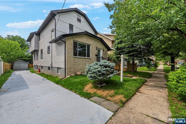 222 4th St, Ridgefield Park, NJ 07660 - view of side of home with concrete driveway, an outbuilding, and brick siding