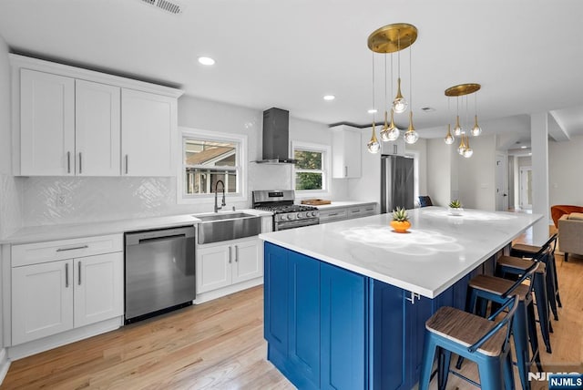 222 4th St, Ridgefield Park, NJ 07660 - kitchen with stainless steel appliances, wall chimney range hood, light wood-style flooring, white cabinetry, and recessed lighting