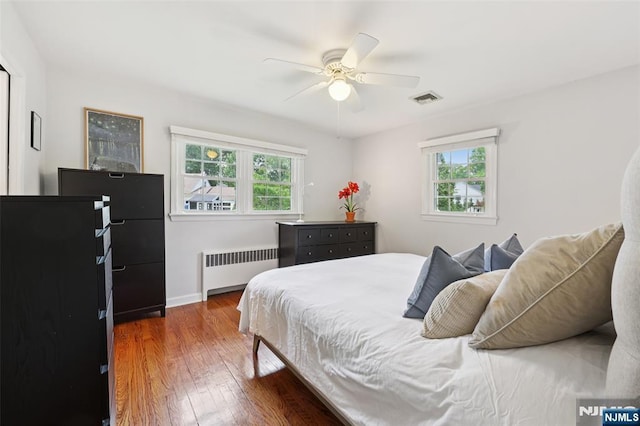 21 Valley Forge Way, Ho-Ho-Kus, NJ 07423 - bedroom with radiator heating unit, multiple windows, wood finished floors, and ceiling fan