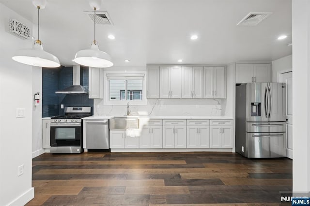 26 Amsterdam Ave, Teaneck, NJ 07666 - kitchen featuring wall chimney exhaust hood, appliances with stainless steel finishes, light countertops, dark wood-type flooring, and tasteful backsplash