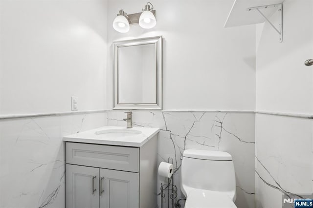 26 Amsterdam Ave, Teaneck, NJ 07666 - half bathroom with tile walls, vanity, and a wainscoted wall