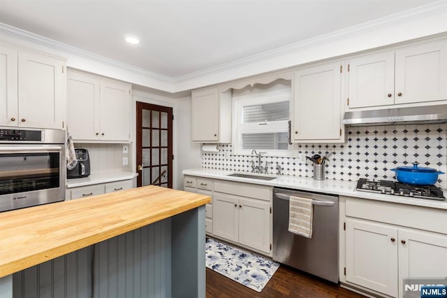 286 Willow Ave, Lyndhurst, NJ 07071 - kitchen with appliances with stainless steel finishes, wood counters, under cabinet range hood, tasteful backsplash, and crown molding