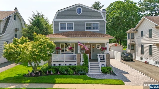 36 First, Hawthorne, NJ 07506 - view of front of home with covered porch, a gambrel roof, an outdoor structure, a front lawn, and a garage