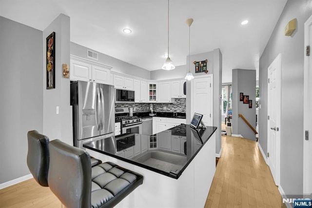 303 Wilshire Dr, Nutley, NJ 07110 - kitchen featuring appliances with stainless steel finishes, dark countertops, white cabinets, tasteful backsplash, and recessed lighting