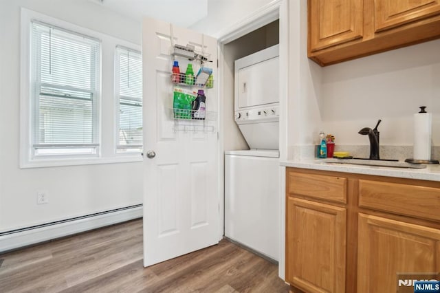 322 3rd St, Saddle Brook, NJ 07663 - laundry room with stacked washer and clothes dryer, baseboard heating, and wood finished floors