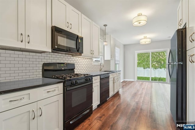 322 3rd St, Saddle Brook, NJ 07663 - kitchen with black appliances, dark countertops, dark wood-style flooring, and white cabinets