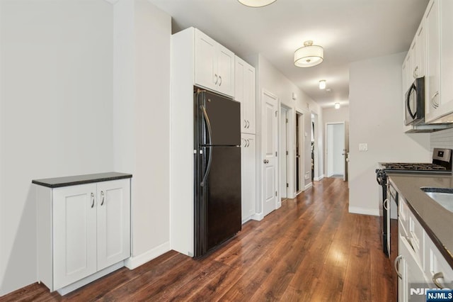 322 3rd St, Saddle Brook, NJ 07663 - kitchen with black appliances, dark countertops, dark wood-style floors, and white cabinetry
