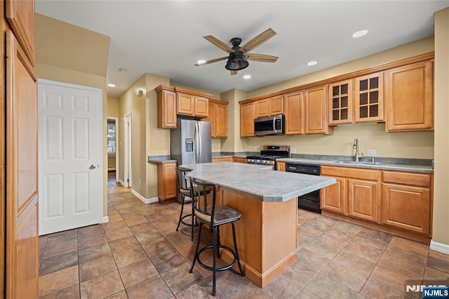 115 12th St, Prospect Park, NJ 07508 - kitchen featuring stainless steel appliances, a breakfast bar area, a kitchen island, ceiling fan, and glass insert cabinets
