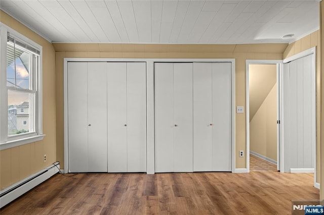 115 12th St, Prospect Park, NJ 07508 - unfurnished bedroom with a baseboard heating unit, multiple closets, wood finished floors, and crown molding