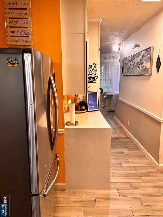 188 Hoyt St, Kearny, NJ 07032 - kitchen featuring freestanding refrigerator, a textured ceiling, and light wood-type flooring