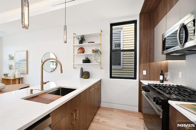 29 Armstrong Ave Unit 3, Jersey City, NJ 07305 - kitchen featuring appliances with stainless steel finishes, light wood-style flooring, open shelves, hanging light fixtures, and modern cabinets