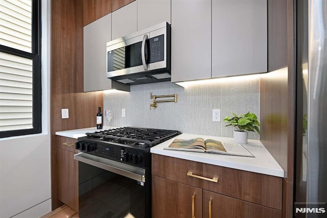 29 Armstrong Ave Unit 3, Jersey City, NJ 07305 - kitchen featuring gas range, stainless steel microwave, modern cabinets, and light countertops