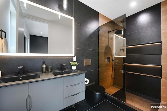 29 Armstrong Ave Unit 3, Jersey City, NJ 07305 - bathroom featuring double vanity, a walk in shower, tile patterned floors, and tile walls