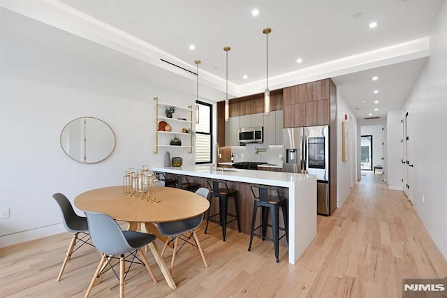 29 Armstrong Ave Unit 3, Jersey City, NJ 07305 - kitchen featuring stainless steel appliances, a kitchen bar, light wood-style floors, a peninsula, and recessed lighting