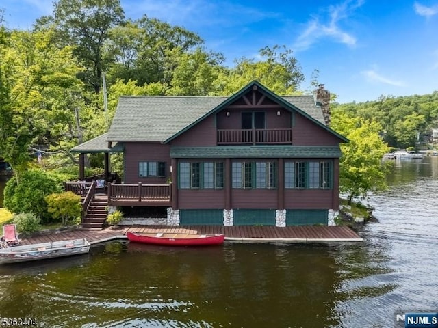 19 Division Ln, Byram, NJ 07821 - back of house featuring a chimney, a shingled roof, a balcony, a deck with water view, and a forest view
