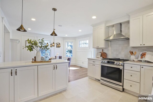 46 Oak Ridge Ave, Nutley, NJ 07110 - kitchen featuring stainless steel gas range, wall chimney range hood, backsplash, light countertops, and decorative light fixtures