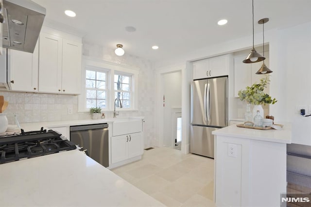 46 Oak Ridge Ave, Nutley, NJ 07110 - kitchen with appliances with stainless steel finishes, range hood, light countertops, white cabinetry, and decorative light fixtures