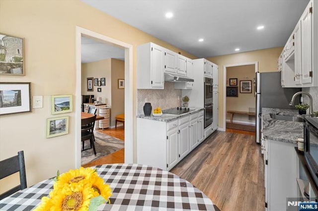 206 Wind Hollow Ct, Mahwah, NJ 07430 - kitchen with black electric stovetop, backsplash, wood finished floors, white cabinetry, and recessed lighting