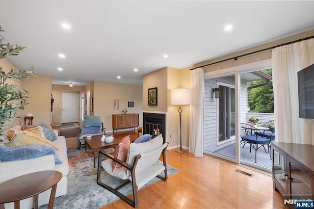 206 Wind Hollow Ct, Mahwah, NJ 07430 - living area featuring light wood-style flooring, a lit fireplace, and recessed lighting
