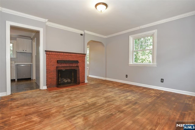 36 Grove St, Waldwick, NJ 07463 - unfurnished living room with wood finished floors, arched walkways, crown molding, and a brick fireplace