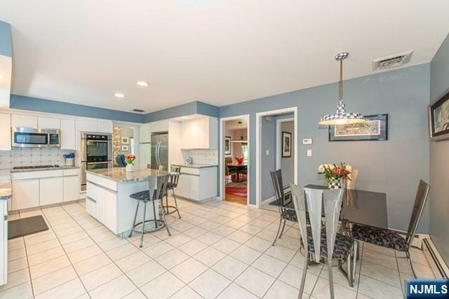 5 Hurley Ct, Wyckoff, NJ 07481 - kitchen with appliances with stainless steel finishes, backsplash, white cabinets, light tile patterned flooring, and recessed lighting